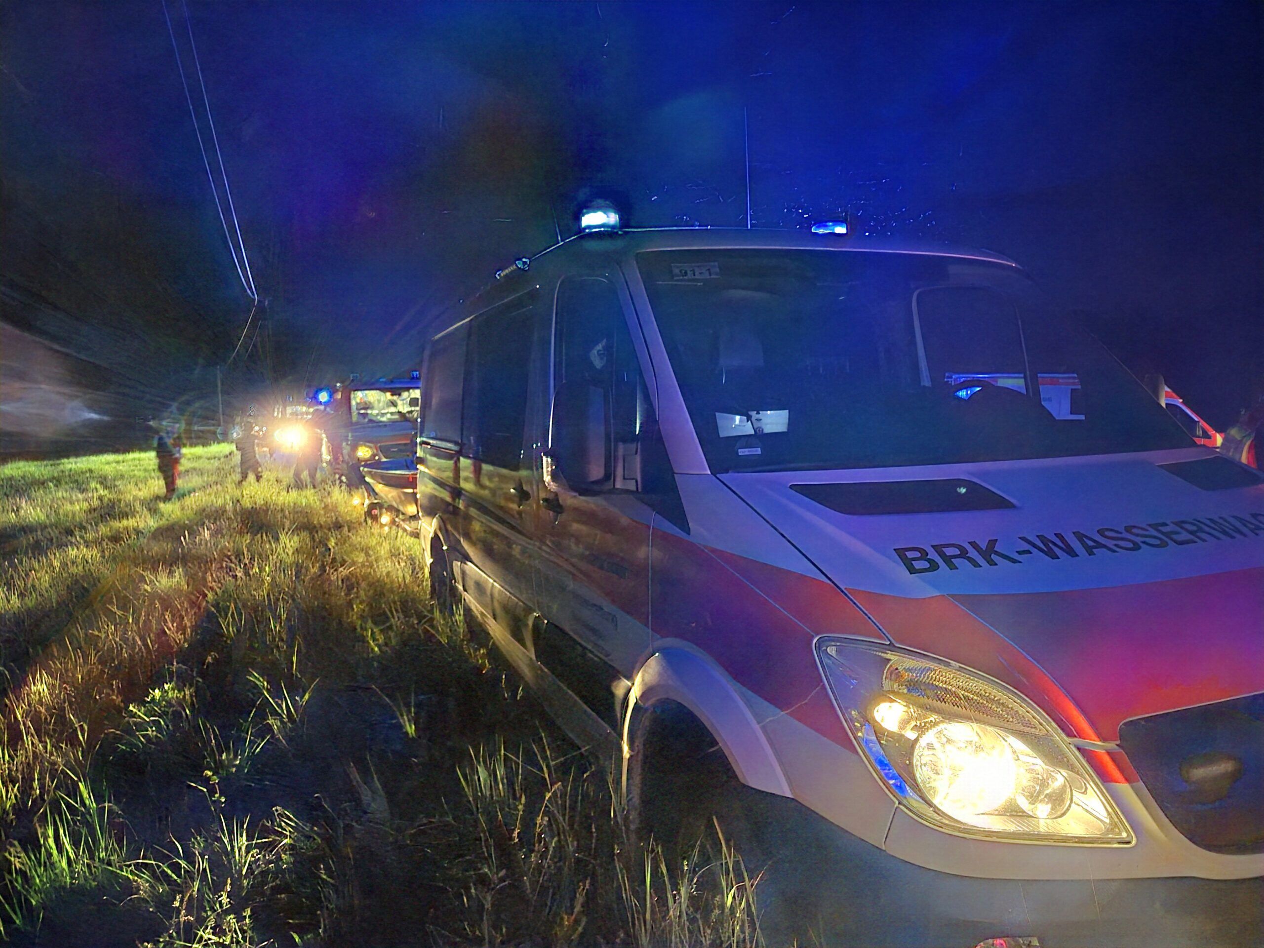 Einsatzfahrzeuge der Wasserwacht bei Nacht während einem Einsatz