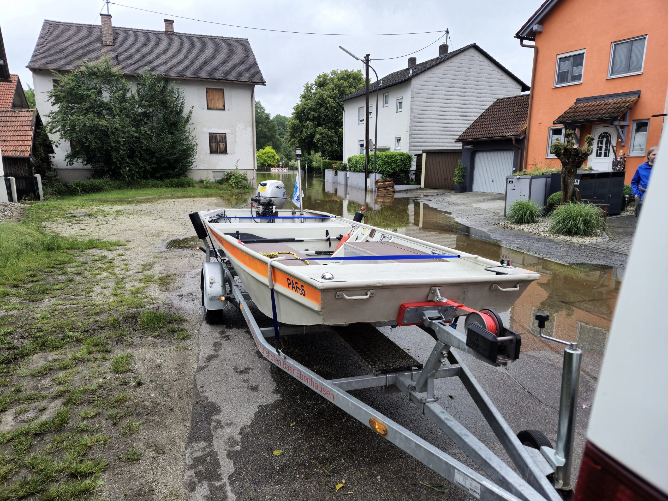 Motorrettungsboot auf Trailer vor überfluteter Straße während Hochwasser 2024 Bayern 